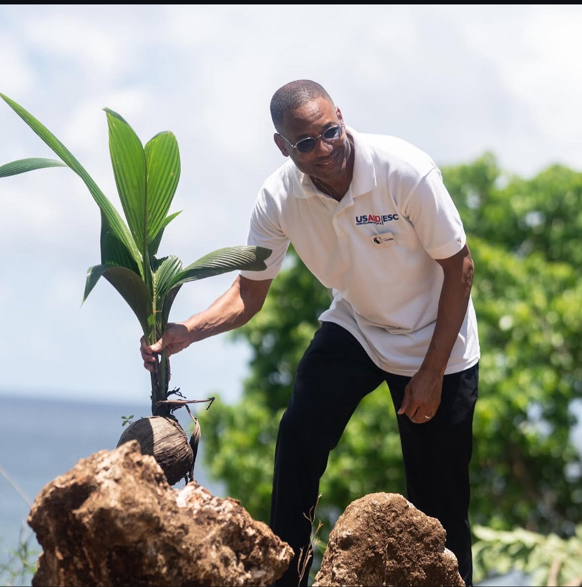 Clinton White A man holding a plant just harvested from a field